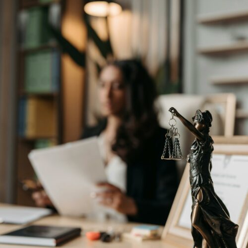 Statue of scale of justice with background of lawyer