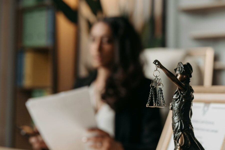 Statue of scale of justice with background of lawyer